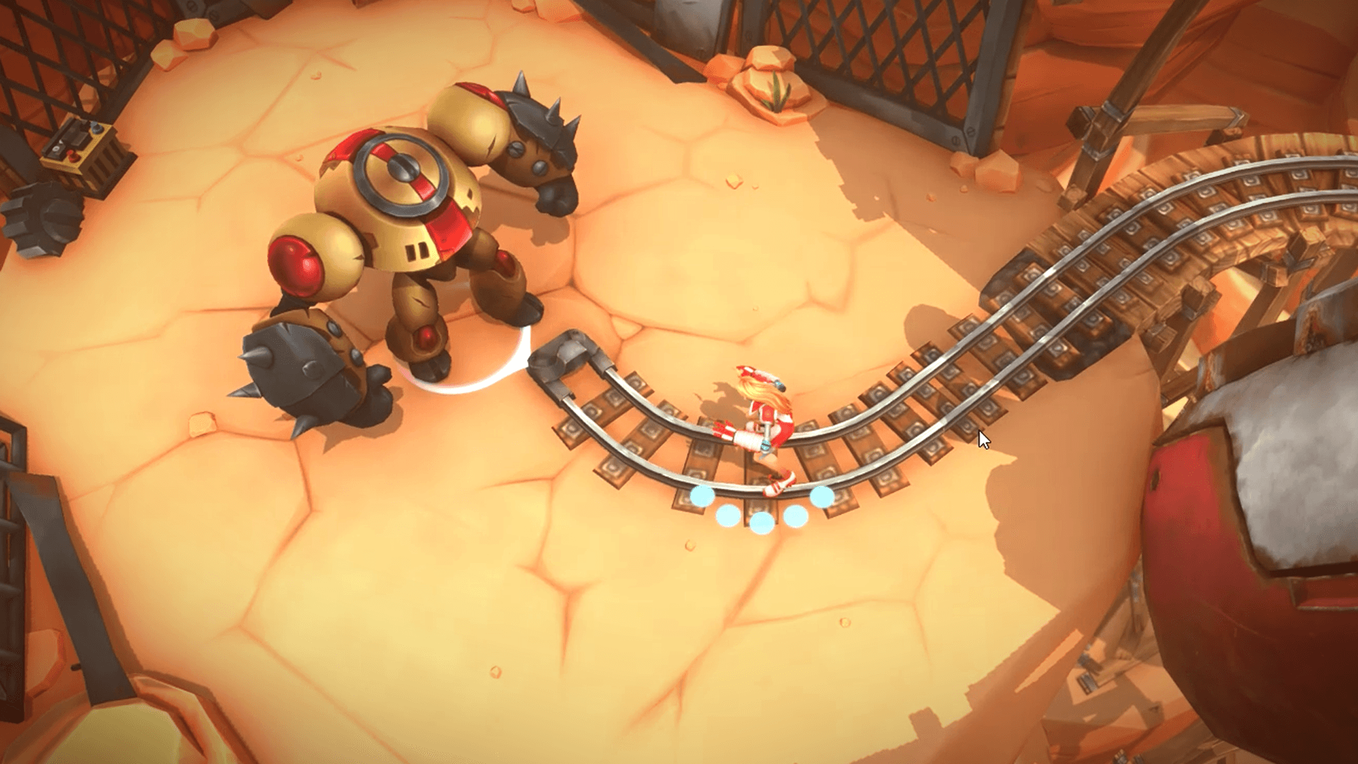 This vibrant overhead shot from a video game showcases a desert-themed level with a large, imposing robot and a smaller character on a winding minecart track. The robot, with its gold and red armor and spiked fists, appears to be a formidable opponent, while the character in red and white seems to be navigating the track with glowing blue orbs. The cracked, sandy terrain and industrial elements like the minecart tracks and metal structures create an adventurous and slightly perilous atmosphere.